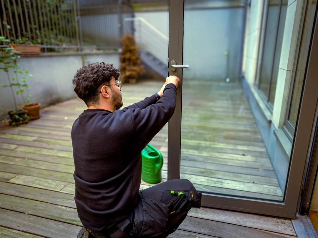 Le serrurier Luck Lock travaille sur la fermeture d’une porte vitrée.